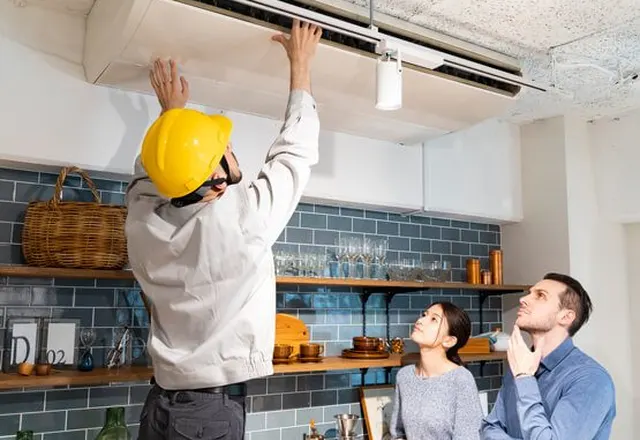 Électricien installant un équipement au plafond